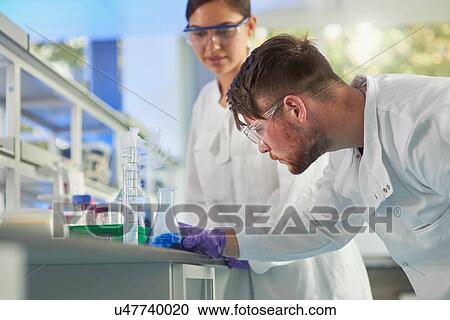 Stock Image - Scientist examining conical flask. Fotosearch