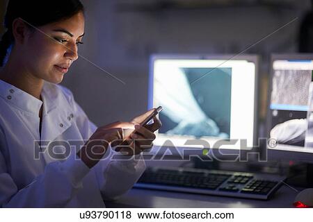 Scientist in laboratory texting on smartphone View Large Photo Image Stock Photo - Scientist in laboratory texting on smartphone. Fotosearch