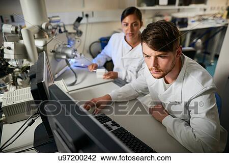 Stock Image - Scientist in laboratory using computer. Fotosearch