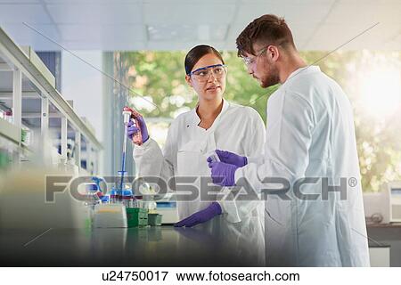 Stock Photo - Scientist in laboratory using electronic pipette. Fotosearch