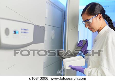 Stock Photograph - Scientist in laboratory using scientific equipment. Fotosearch