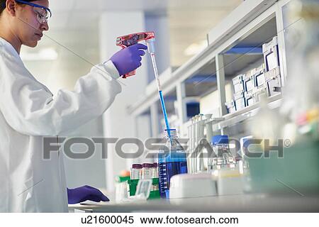 Stock Photography - Scientist in laboratory using electronic pipette. Fotosearch