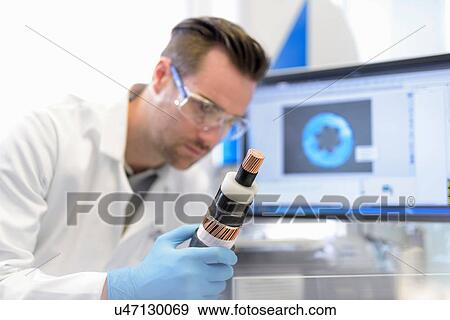 Scientist inspecting electrical cable in cable storage facility View Large Photo Image Stock Photo - Scientist inspecting electrical cable in cable storage facility. Fotosearch