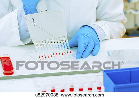 Stock Photo - Scientist using micropipettes. Fotosearch