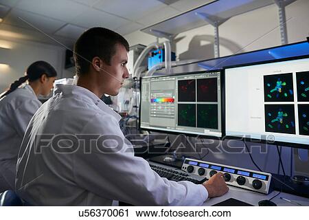 Stock Image - Scientists in laboratory using computer. Fotosearch