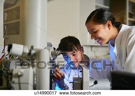 Scientists in laboratory using scientific equipment smiling View Large Photo Image Stock Photo - Scientists in laboratory using scientific equipment smiling. Fotosearch
