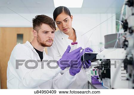 Stock Photo - Scientists in laboratory using scientific equipment. Fotosearch