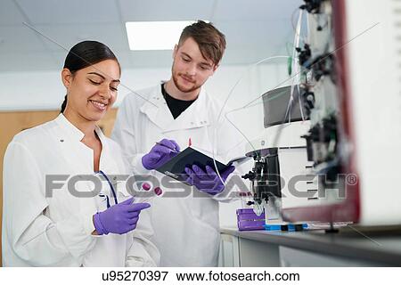 Stock Photo - Scientists in laboratory using scientific equipment. Fotosearch
