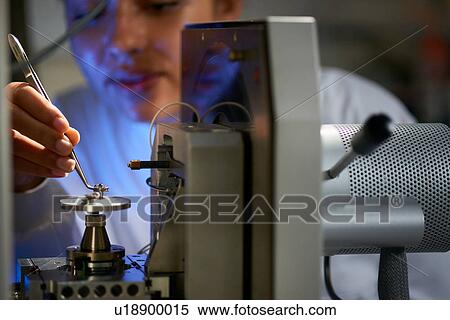 Scientists placing object on scientific equipment using tweezers View Large Photo Image Stock Photography - Scientists placing object on scientific equipment using tweezers. Fotosearch