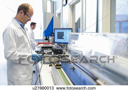 Stock Image - Scientists testing electrical cables in cable storage facility. Fotosearch