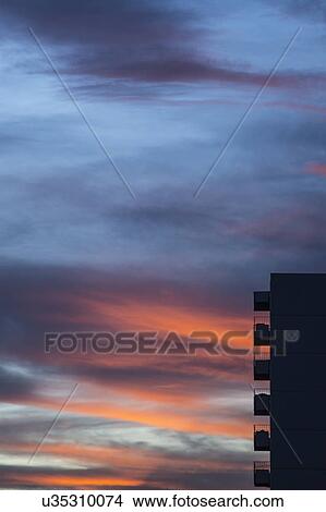 Picture - Silhouette of apartment building against colorful sky at sunset. Fotosearch