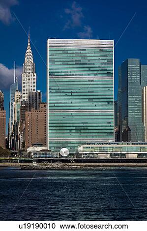 Stock Image - Skyline of Midtown Manhattan seen from the East River showing the Chrysler Building and the United Nations building, New York. Fotosearch