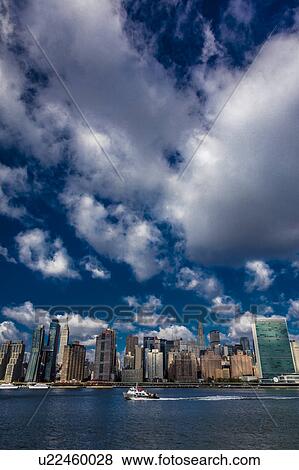 Stock Photo - Skyline of Midtown Manhattan seen from the East River showing the Chrysler Building and the United Nations building, New York. Fotosearch