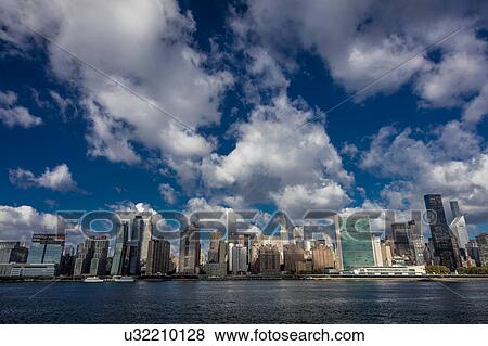 Skyline of Midtown Manhattan seen from the East River showing the Chrysler Building and the United Nations building, New York View Large Photo Image Stock Photo - Skyline of Midtown Manhattan seen from the East River showing the Chrysler Building and the United Nations building, New York. Fotosearch