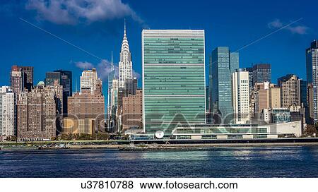 Stock Photo - Skyline of Midtown Manhattan seen from the East River showing the Chrysler Building and the United Nations building, New York. Fotosearch