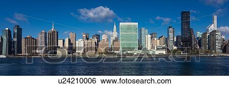 Stock Photograph - Skyline of Midtown Manhattan seen from the East River showing the Chrysler Building and the United Nations building, New York. Fotosearch