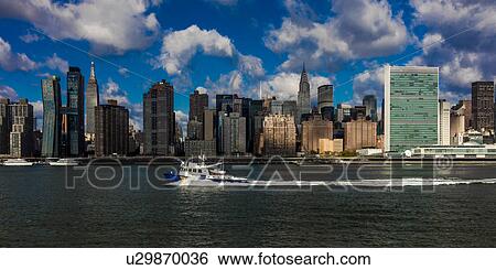 Stock Photograph - Skyline of Midtown Manhattan seen from the East River showing the Chrysler Building and the United Nations building, New York. Fotosearch