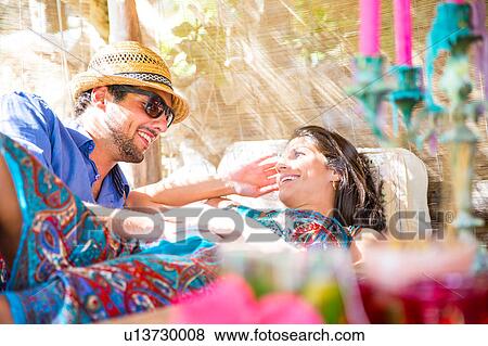Stock Photo - Smiling couple lying down taking chatting. Fotosearch