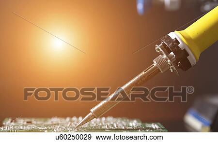 Stock Photo - Soldering a printed circuit board. Fotosearch