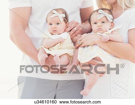 Studio shot portrait of two baby girls (2-5 months) with parents View Large Photo Image Stock Image - Studio shot portrait of two baby girls (2-5 months) with parents. Fotosearch