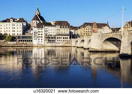 Stock Image - Switzerland, Basel, Basel-Stadt, Houses by Rhine River and stone bridge. Fotosearch