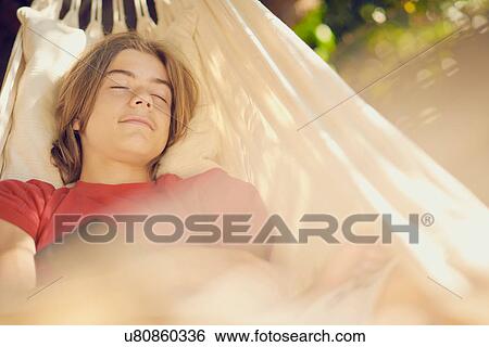 Teenage boy reclining in garden hammock asleep View Large Photo Image Stock Photograph - Teenage boy reclining in garden hammock asleep. Fotosearch
