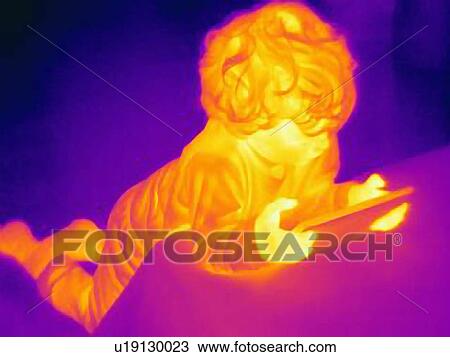 Stock Image - Thermal image of male toddler looking at digital tablet. Fotosearch