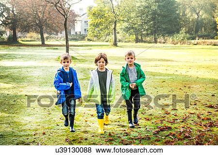 Three boys, outdoors, walking across field View Large Photo Image Stock Photo - Three boys, outdoors, walking across field. Fotosearch