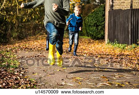 Three boys, running along pathway in autumn, low section View Large Photo Image Stock Photo - Three boys, running along pathway in autumn, low section. Fotosearch