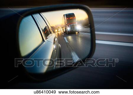 Stock Photo - Truck on road reflecting in rear view mirror. Fotosearch