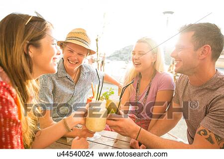 Two adult couples making a cocktail toast at waterfront restaurant, Majorca, Spain View Large Photo Image Picture - Two adult couples making a cocktail toast at waterfront restaurant, Majorca, Spain. Fotosearch