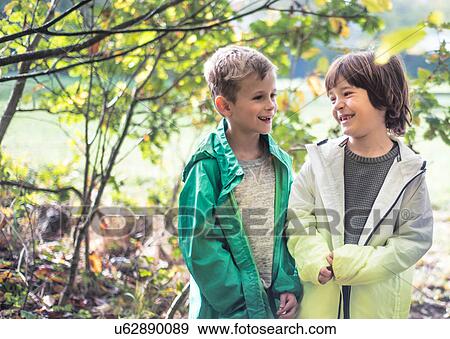Two boys in park, standing together, laughing View Large Photo Image Stock Photo - Two boys in park, standing together, laughing. Fotosearch