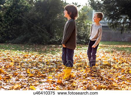 Stock Photography - Two boys playing outdoors, in autumn leaves. Fotosearch