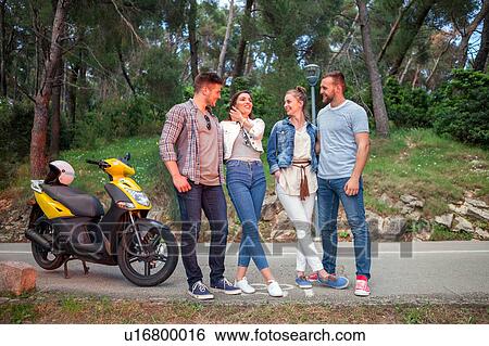 Stock Photograph - Two couples with moped chatting on rural road, Split, Dalmatia, Croatia. Fotosearch