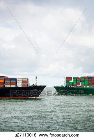 Stock Photo - Two large container ships cross each other at entrance of Rotterdam harbour, Netherlands. Fotosearch