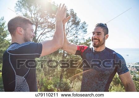 Two male runners high fiving in park, Split, Dalmatia, Croatia View Large Photo Image Stock Image - Two male runners high fiving in park, Split, Dalmatia, Croatia. Fotosearch