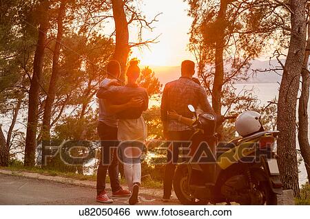 Two moped couples looking out at sunset from coastal road, Split, Dalmatia, Croatia View Large Photo Image Stock Photograph - Two moped couples looking out at sunset from coastal road, Split, Dalmatia, Croatia. Fotosearch