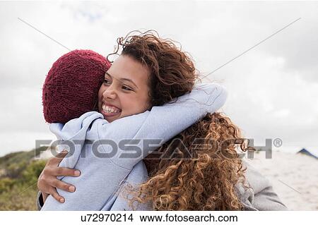Picture - Two young female friends hugging at beach, Western Cape, South Africa. Fotosearch