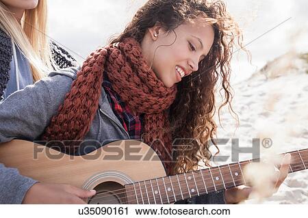 Two young female friends playing guitar at beach, Western Cape, South Africa View Large Photo Image Stock Image - Two young female friends playing guitar at beach, Western Cape, South Africa. Fotosearch