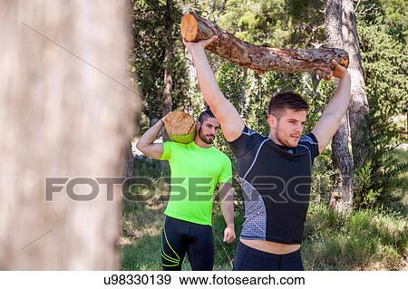 Stock Photo - Two young men doing weightlifting training with logs in forest, Split, Dalmatia, Croatia. Fotosearch