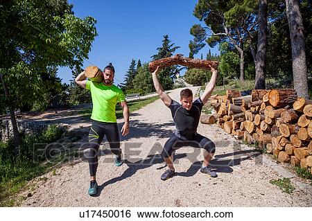 Two young men doing weightlifting training with logs in forest, Split, Dalmatia, Croatia View Large Photo Image Stock Photograph - Two young men doing weightlifting training with logs in forest, Split, Dalmatia, Croatia. Fotosearch
