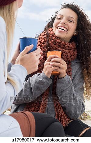 Two young women laughing at beach picnic, Western Cape, South Africa View Large Photo Image Stock Photo - Two young women laughing at beach picnic, Western Cape, South Africa. Fotosearch