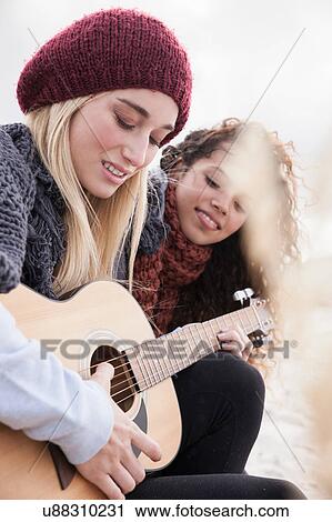Two young women playing guitar at beach, Western Cape, South Africa View Large Photo Image Stock Image - Two young women playing guitar at beach, Western Cape, South Africa. Fotosearch