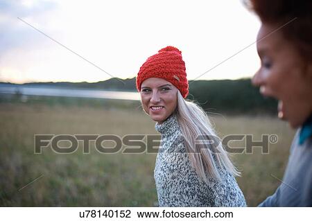 Stock Image - Two young women strolling in coastal field. Fotosearch