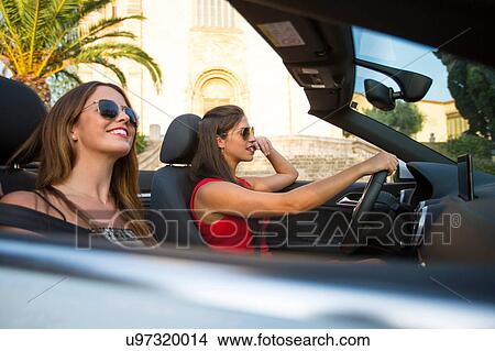 Two young women tourists driving convertible, Calvia, Majorca, Spain View Large Photo Image Picture - Two young women tourists driving convertible, Calvia, Majorca, Spain. Fotosearch