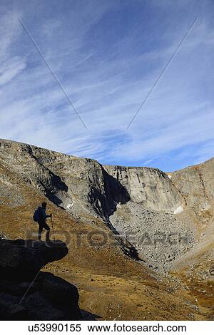Stock Photography - USA, Colorado, Silhouette of hiker on rock ledge along Chicago Lakes Trail in Mount Evans Wilderness Area. Fotosearch