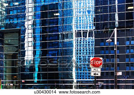 Picture - USA, New York, Distorted reflections in office building and stop sign in front. Fotosearch