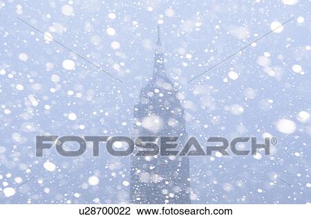 Stock Image - USA, New York State, New York City, Empire State Building in snow. Fotosearch
