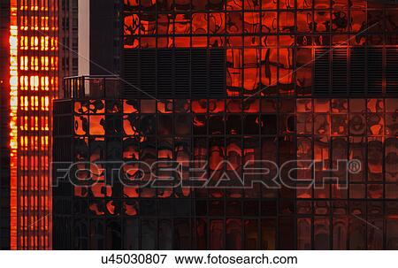 Stock Photo - USA, New York State, New York City, Reflection on glass facade of office building at sunset. Fotosearch