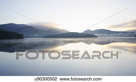 Stock Image - USA, New York, Sunrise over Lake Placid. Fotosearch